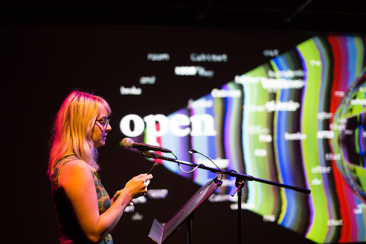 Projected words emitting from Meghann Plunkett's mouth at a microphone