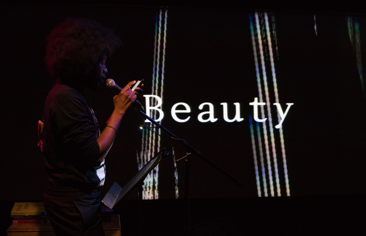 Playwright Jeremy O. Harris with the word BEAUTY projected behind him
